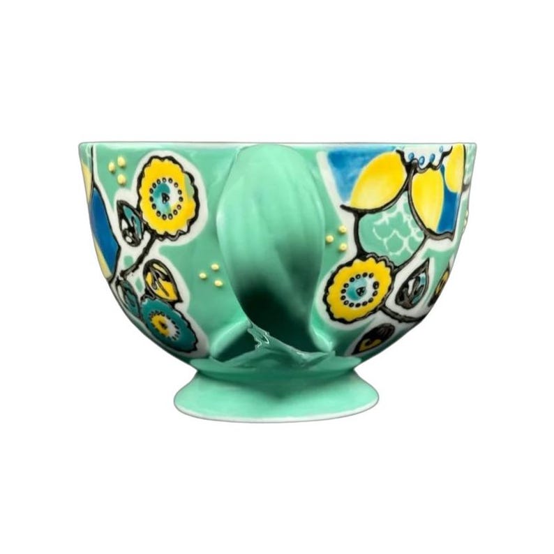 Anthropologie Elka Ayaka green floral pedestal mug with hand painted yellow and blue blooms on glossy ceramic