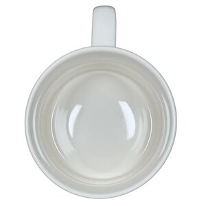 Top view of white ceramic Alexandre Dumas G monogram initial mug empty with handle on black background