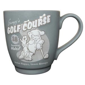 May include: A white ceramic mug with a black handle and the text "But First, Coffee" in a black, bold font. The mug is sitting on a wooden surface. The mug is approximately 4 inches tall.