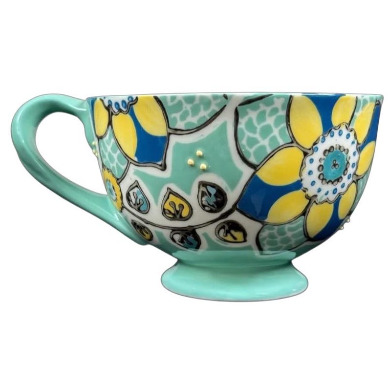 Anthropologie Elka Ayaka green floral pedestal mug with yellow blue flower pattern and gold dot accents