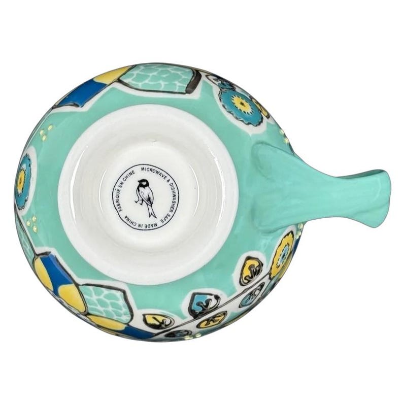 Top view of Anthropologie Elka Ayaka green floral pedestal mug showing turquoise handle and yellow blue floral pattern