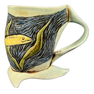 Peut inclure: Une tasse en céramique au design unique représentant un poisson jaune nageant dans de l'eau bleue et noire avec des algues vertes. La tasse a une anse incurvée et une base qui s'étend vers l'extérieur. La tasse est peinte avec une finition brillante.