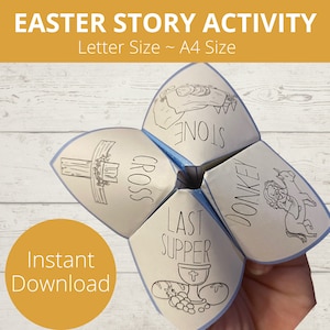 May include: A blue and white paper game with five panels. Each panel has a different image and text related to the Easter story. The panels include a cross, a stone, a donkey, a last supper, and a garden. The text on the panels reads "CROSS", "STONE", "DONKEY", "LAST SUPPER", and "GARDEN".