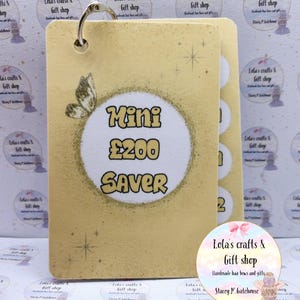 May include: A gold-coloured Mini £200 Saver card with a butterfly graphic and a metal ring. The card has a textured surface and a white circle with the text "Mini £200 SAVER". Additional cards are visible to the right.