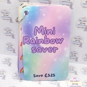 May include: A Mini Rainbow Saver, a savings tracker, features a colourful, pastel rainbow design. The text "Mini Rainbow Saver" is in purple, with "Save £525" below. The tracker is held together with a silver ring.