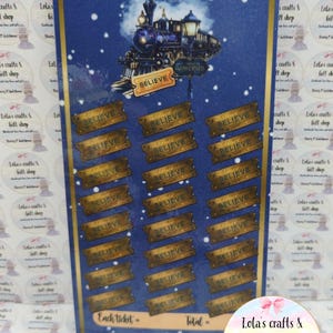 May include: A blue and gold decorative sign featuring a train illustration with the text "Believe". The sign has multiple "Believe" ticket-shaped sections. The sign is from "Lola's crafts & gift shop".