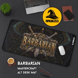 May include: Black rectangular desk mat with a "Barbarian" design featuring crossed swords and a warrior illustration. The mat includes the text "Mastercraft Alt Desk Mat" and a logo. A computer mouse, laptop, and other office supplies are visible.