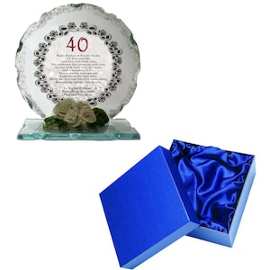 May include: A clear glass plaque with a decorative edge, featuring the number "40" and a poem. The plaque rests on a glass base with a floral accent. A blue gift box with a satin lining is also included.