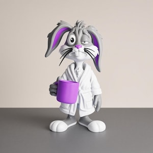Könnte beinhalten: Eine grau-weiße Kaninchenfigur in einem weißen Bademantel, die einen einfarbigen violetten Becher hält. Das Kaninchen hat lange Ohren mit violettem Innenfutter, eine rosa Nase, schwarze Schnurrhaare und einen müden Gesichtsausdruck.
