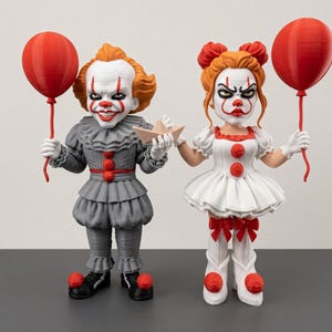 Könnte beinhalten: Zwei stilisierte Clown-Figuren, eine in einem grauen Rüschenoutfit und eine in einem weißen Kleid, beide mit orangefarbenen Haaren und rotem Make-up. Jede Figur hält einen leuchtend roten Ballon, und die grau gekleidete Figur hält ein kleines beiges Papierboot.