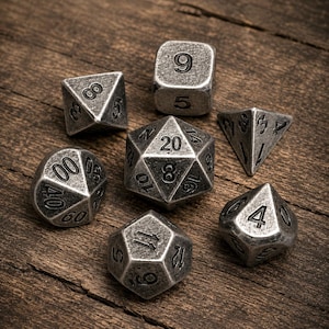 Puede incluir: Un juego de siete dados poliédricos con un acabado metálico plateado desgastado y números grabados en negro. La colección incluye un d20, d12, d10, d8, d6, d4 y un dado de porcentaje, todos con bordes afilados y una apariencia envejecida.