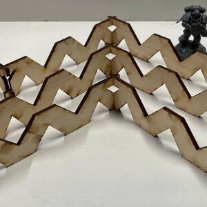 May include: Five wooden zig-zag pieces, each with a series of connected points, forming a decorative pattern. The pieces are arranged in a symmetrical pattern, with the center piece forming a point.