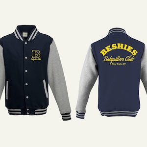 May include: Navy blue and gray letterman jacket with the text "Beshies Babysitters Club" in yellow. The jacket has a navy blue body, gray sleeves, and white and gray striped cuffs and collar. The front features a yellow "B" and the words "Babysitters Club".