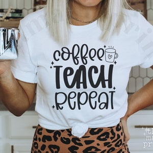 May include: White t-shirt with black text that reads "coffee teach repeat" and a small coffee cup with a heart on it.