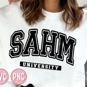 May include: White sweatshirt with black text that reads "SAHM UNIVERSITY". The text is in a distressed, vintage style font.