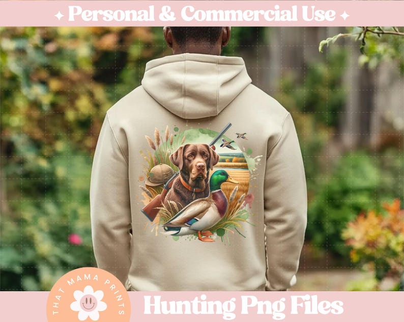 Puede incluir: Una sudadera con capucha beige con un dise&ntilde;o de tem&aacute;tica de caza que presenta un perro marr&oacute;n y negro, un pato verde y una escopeta. El dise&ntilde;o est&aacute; rodeado de vegetaci&oacute;n de estilo acuarela y un fondo marr&oacute;n claro.