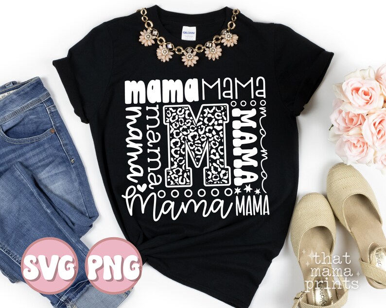 Pode incluir: Camiseta preta com um design gr&aacute;fico branco que apresenta a palavra "mama" repetida em diferentes estilos e tamanhos. O gr&aacute;fico tamb&eacute;m inclui uma letra "M" grande com um padr&atilde;o de estampa de leopardo. A camiseta est&aacute; colocada sobre uma superf&iacute;cie branca.