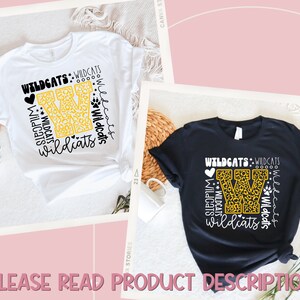 May include: Two t-shirts with a black and yellow design featuring the letter "W" with a leopard print pattern. The text "Wildcats" is repeated multiple times around the letter "W" with a heart and paw print.