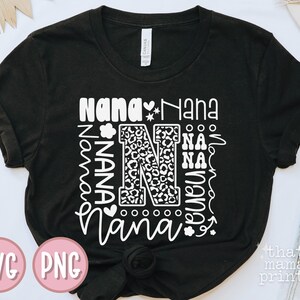 May include: Black t-shirt with a white design that says "Nana" multiple times in different fonts and sizes. The design also includes a large letter "N" with a leopard print pattern.