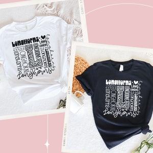 May include: Two t-shirts, one white and one black, with a graphic design featuring the word "Longhorns" repeated in a variety of sizes and styles. The design also includes a heart and a leopard print letter "L".