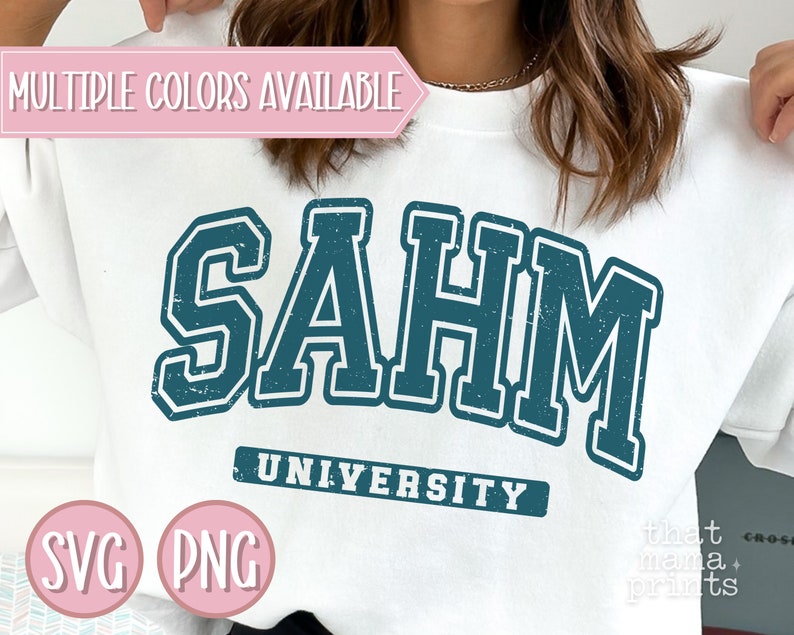 May include: White sweatshirt with a distressed teal blue graphic that says "SAHM UNIVERSITY". The graphic is in a vintage collegiate style font.