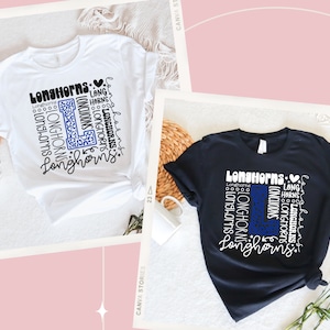 May include: Two t-shirts with a graphic design of the word "Longhorns" repeated in a pattern to form the letter "L". The design is in white with a blue and black leopard print inside the "L". One shirt is white and the other is black.