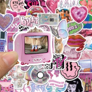 May include: A sheet of pink and white stickers with various designs, including a pink television with a cartoon image of a girl wearing red shoes, a pink butterfly, a pink heart, a pink lip, and a pink and white checkered pattern. The stickers are perfect for decorating laptops, water bottles, journals, and other items.