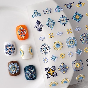 May include: Nail art stickers featuring blue, yellow, and white floral and geometric patterns. Several painted nails are shown, displaying the sticker designs on orange, white, brown, and teal nail polish.