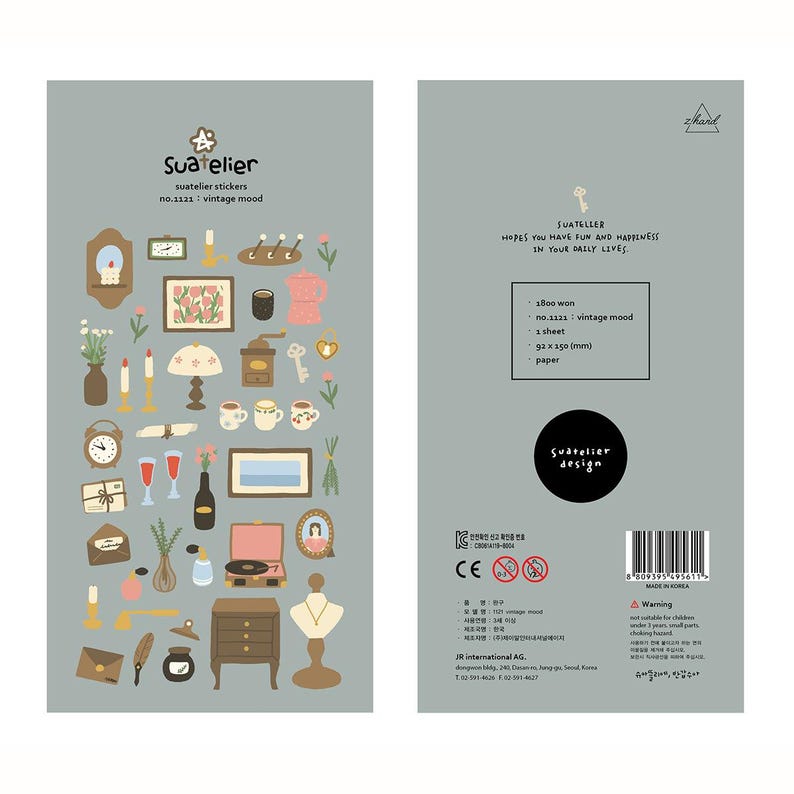 May include: A sheet of Suatelier vintage mood stickers. The stickers feature various vintage-themed illustrations, including clocks, keys, lamps, and teacups. The sheet is gray with text that reads "Suatelier" and "vintage mood."