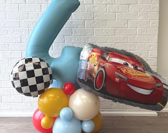 May include: A festive balloon arrangement featuring a large light blue number 4 balloon, a checkered balloon, and a red race car balloon. Additional balloons in red, yellow, white, and blue complete the celebratory display.