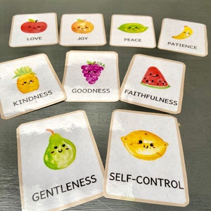 Pode incluir: Nove cartas coloridas com ilustra&ccedil;&otilde;es de frutas e palavras que representam os frutos do esp&iacute;rito: amor, alegria, paz, paci&ecirc;ncia, bondade, gentileza, fidelidade, mansid&atilde;o e dom&iacute;nio pr&oacute;prio.