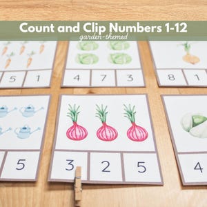 May include: A set of educational cards featuring garden-themed illustrations of vegetables and watering cans. Each card displays a quantity of items with three numerical options below, including the text Count and Clip Numbers 1-12.