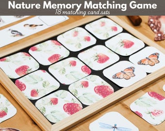 Op de afbeelding: Een Nature Memory Matching Game met 18 bijpassende kaartensets. Het spel bevat vierkante kaarten met afgeronde hoeken met illustraties van aardbeien, vlinders en libellen, gerangschikt in een licht houten frame dienblad.