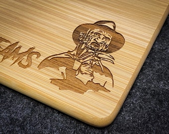 May include: A wooden chopping board with a laser-engraved image of Freddy Krueger from the film "A Nightmare on Elm Street". The text "Dreams" is also engraved on the board.