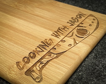May include: A wooden chopping board with the text "Cooking with Jason" and a stylised knife design engraved into the surface.