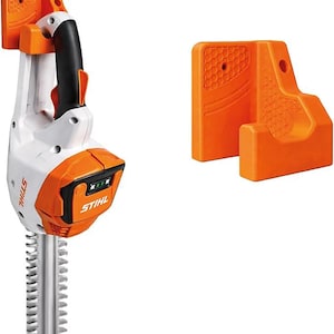Op de afbeelding: Een witte en oranje STIHL snoerloze heggenschaar met een zwarte handgreep en een zilverkleurig mes. De trimmer heeft een batterij-indicator en wordt geleverd met een oranje wandhouder.