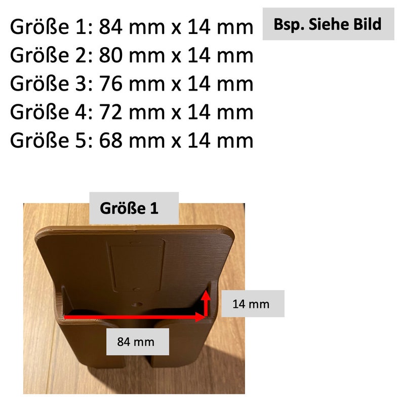 Op de afbeelding: Een bruine plastic wandbevestiging met een rechthoekige opening. De opening is 84 mm breed en 14 mm hoog. De tekst "Gr&ouml;&szlig;e 1" is zichtbaar op de bevestiging.