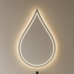 May include: A contemporary bathroom vanity featuring a teardrop-shaped mirror with an illuminated border. Below, there's a white oval sink, a tap, and a soap dispenser. The vanity is set against a neutral wall.