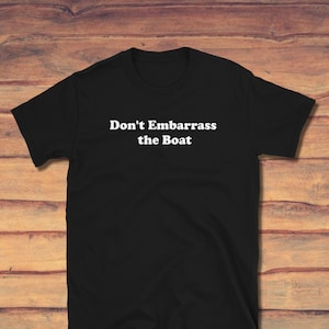 May include: Black t-shirt with white text that reads "Don't Embarrass the Boat".