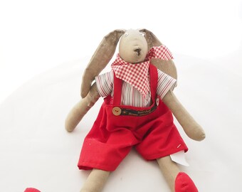 Hand-sewn stuffed rabbit in red dungarees