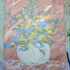 May include: A painting of a white vase filled with blue, yellow, and green flowers. The background is a light brown color.