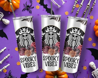 May include: Three white stainless steel tumblers with black lids and black straws. Each tumbler features a black and white skeleton with a crown and floral design. The text "Spooky Vibes" is printed in black on each tumbler.