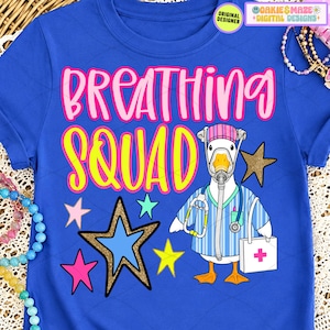 Peut inclure: T-shirt bleu avec l'inscription "BREATHING SQUAD" en rose et jaune. Un canard de dessin animé portant un masque médical, une blouse et tenant un stéthoscope est représenté. Le design comprend des étoiles et un sac médical.