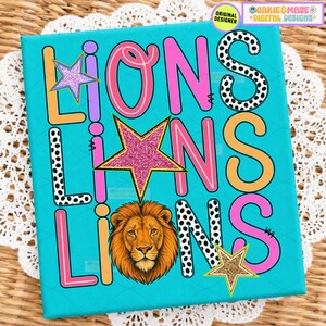 May include: A bright turquoise graphic print featuring the word LIONS repeated three times in various fonts and colors, including pink, orange, and black-and-white polka dots, accented with glittery pink and gold stars and a lion head illustration.