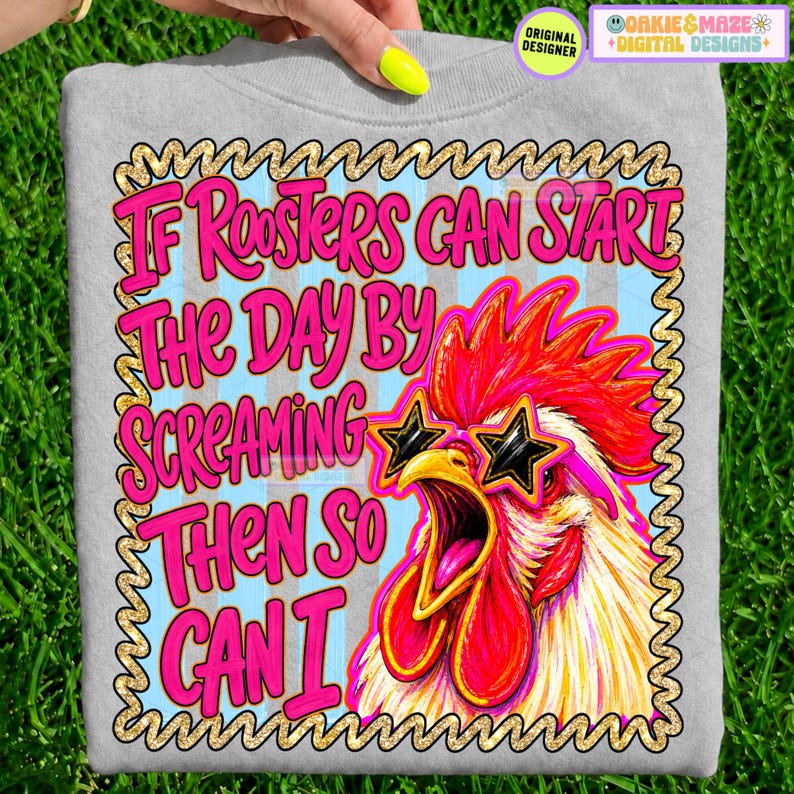 May include: A light gray sweatshirt featuring a graphic of a rooster wearing star-shaped sunglasses. The text reads: If Roosters Can Start The Day By Screaming Then So Can I. The design is framed by a gold-colored border on a light blue background.
