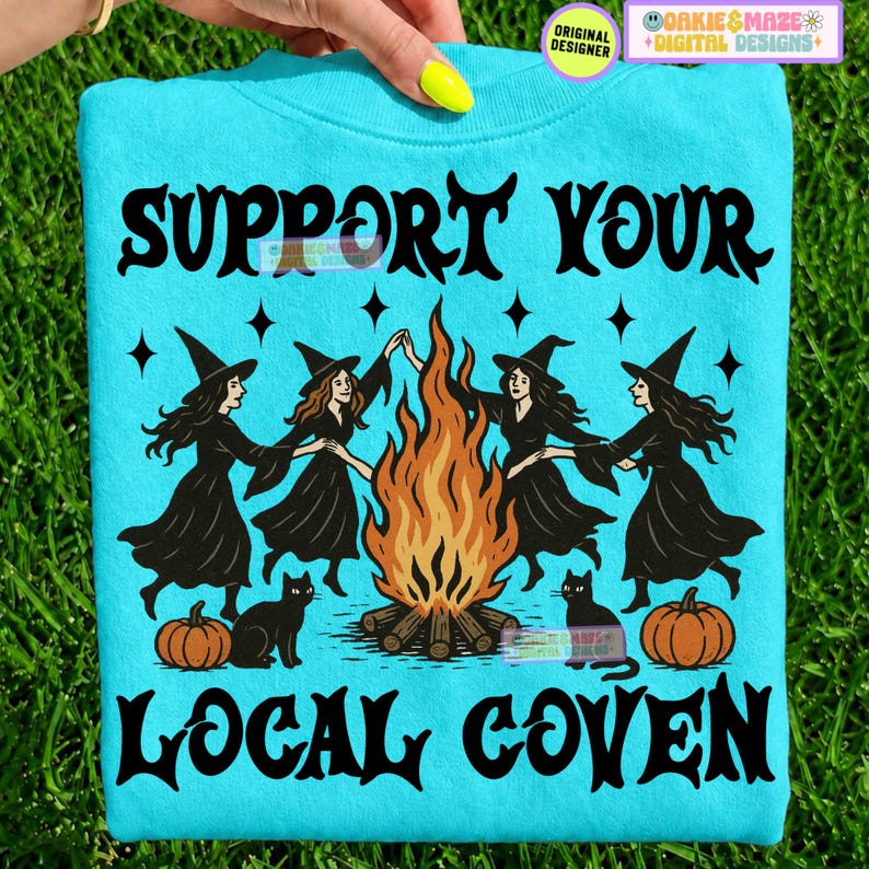May include: A bright turquoise sweatshirt featuring a black graphic of four witches dancing around a campfire. The text reads SUPPORT YOUR LOCAL COVEN in a bold black font. Two black cats and two orange pumpkins are positioned at the base.