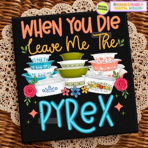 May include: A black rectangular sign featuring the text "WHEN YOU DIE Leave Me The PYREX" in orange and yellow. The design includes a stack of colorful vintage-style patterned glass bowls and casserole dishes, accented with pink and blue flowers.