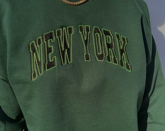 Sudadera unisex con cuello redondo y bordado verde de Nueva York