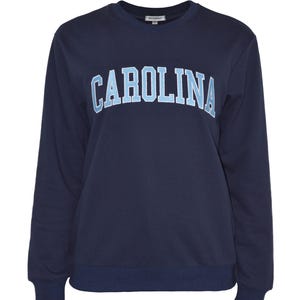 Puede incluir: Sudadera azul marino de cuello redondo con la palabra "CAROLINA" en letras may&uacute;sculas azul claro en el pecho. La sudadera tiene mangas largas y dobladillo y pu&ntilde;os de canal&eacute;. Un dise&ntilde;o sencillo y cl&aacute;sico.