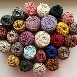 May include: A collection of 30 colorful balls of yarn, each wound into a tight circle. The yarn is a variety of colors, including red, blue, green, yellow, orange, purple, pink, brown, and white.